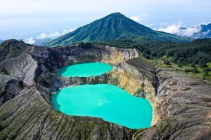 Drone view of the Kelimutu lakes cradled by forested valley ridges
